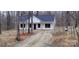 A charming exterior view of a modern home nestled among the trees with a gravel driveway at 330 Fiber Acres A St, Cleveland, NC 27013