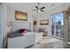 Bright bedroom boasts a large window with city views, wood-look floors, and a ceiling fan at 333 W Trade St # 2704, Charlotte, NC 28202