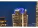 Close-up view of a modern skyscraper illuminated with blue lights at night at 333 W Trade St # 2704, Charlotte, NC 28202