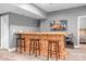 Basement bar featuring natural wood finish, seating, and a mini fridge at 3934 Blue Dory Ln, Denver, NC 28037