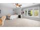 Sunlit bedroom features neutral colors, a ceiling fan, and a large window at 3934 Blue Dory Ln, Denver, NC 28037