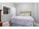 Cozy bedroom with patterned bedding, soft carpet, and a sunny window for natural light at 3934 Blue Dory Ln, Denver, NC 28037