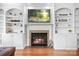 Close-up of living room fireplace with built-in shelving and a wall-mounted television at 3934 Blue Dory Ln, Denver, NC 28037