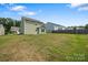 Wide angle of the backyard showing the green grass, the back of the home, and other homes at 4213 Stockbrook Dr, Charlotte, NC 28215