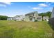 View of the backyard with green grass and a few trees in the background at 4213 Stockbrook Dr, Charlotte, NC 28215