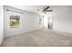 This bright bedroom features neutral-toned carpet, a ceiling fan, and ample natural light at 4213 Stockbrook Dr, Charlotte, NC 28215