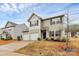 Two-story home featuring a well-maintained yard, a convenient two-car garage, and beautiful landscaping at 4213 Stockbrook Dr, Charlotte, NC 28215