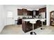 Modern kitchen featuring dark wood cabinets, a center island with seating, and stainless steel appliances at 4213 Stockbrook Dr, Charlotte, NC 28215
