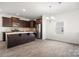 Modern kitchen featuring dark wood cabinets, stainless steel appliances, a stylish backsplash, and marble countertops at 4213 Stockbrook Dr, Charlotte, NC 28215