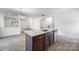 Open-concept living space boasts a large island with sink, wood floors and bright natural light at 4213 Stockbrook Dr, Charlotte, NC 28215