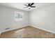 Minimalist bedroom featuring hardwood floors, a ceiling fan, and a window at 4331 Hamilton Cir, Charlotte, NC 28216