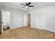 Light bedroom with hardwood floors, a ceiling fan, and a view to the bathroom at 4331 Hamilton Cir, Charlotte, NC 28216