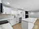 Updated kitchen with island, stainless steel appliances, and white cabinets flowing into living room at 4331 Hamilton Cir, Charlotte, NC 28216
