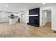 Open living room with hardwood floors, modern kitchen, and black brick fireplace at 4331 Hamilton Cir, Charlotte, NC 28216