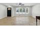 Bright living room features wood floors, large windows, and a modern ceiling fan at 4331 Hamilton Cir, Charlotte, NC 28216