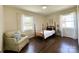 Cozy bedroom featuring a four-poster bed, sitting chair, and bright natural light from dual windows at 4343 Dowling Dr, Charlotte, NC 28205