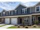 Townhome exterior showcasing stone accents, a one-car garage and a welcoming entrance at 5152 Tommy Ln # 1303, Stanley, NC 28164