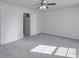 Spacious bedroom with neutral carpet, ceiling fan, and access to a closet at 5670 Hammermill Dr, Harrisburg, NC 28075