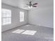 Bright bedroom featuring two windows, a ceiling fan, and neutral carpet at 5670 Hammermill Dr, Harrisburg, NC 28075