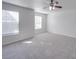 Large bedroom features two windows, a ceiling fan, and soft carpeting at 5670 Hammermill Dr, Harrisburg, NC 28075