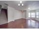 Open-concept area with hardwood floors and staircase, offering versatile layout options at 5670 Hammermill Dr, Harrisburg, NC 28075
