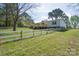 Backyard with wooden deck and white perimeter fence, set against a backdrop of mature trees at 574 Pamela Rd, York, SC 29745