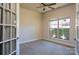 Bedroom boasting french doors, neutral carpet, a ceiling fan, and a large window at 7283 Bradberry Ln, Denver, NC 28037