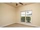 Neutral bedroom with a ceiling fan, carpet floors, and a window with views of the outside at 7283 Bradberry Ln, Denver, NC 28037
