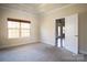 Neutral bedroom showcasing a large window, an open doorway, and a tray ceiling at 7283 Bradberry Ln, Denver, NC 28037
