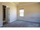 Inviting bedroom featuring neutral walls, an open doorway, a window with blinds, and carpet floors at 7283 Bradberry Ln, Denver, NC 28037