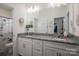 Spacious bathroom with dual sinks, granite countertop, white cabinets, and a large mirror for a luxurious feel at 7924 Creek Park Dr, Denver, NC 28037