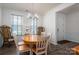 Bright dining room with a chandelier, wood flooring, and natural light streaming through large windows at 7924 Creek Park Dr, Denver, NC 28037