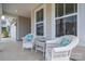 Inviting front porch featuring comfortable wicker chairs, perfect for relaxing and enjoying the outdoors at 7924 Creek Park Dr, Denver, NC 28037