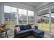 Cozy sunroom with a comfortable couch, large windows, and serene views of the backyard at 7924 Creek Park Dr, Denver, NC 28037