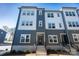 Modern townhome with two-tone gray siding, multiple windows, concrete stairs, and landscaped front yard at 8010 Elevate Ct, Charlotte, NC 28205