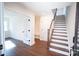 Bright entryway with wood floors, staircase, and coat closet for organized storage at 8010 Elevate Ct, Charlotte, NC 28205