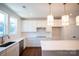 Bright, modern kitchen featuring white cabinets, quartz countertops, and stainless steel appliances at 8010 Elevate Ct, Charlotte, NC 28205