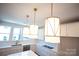 Close-up of stylish pendant lighting over the modern kitchen with white cabinets and stainless steel appliances at 8010 Elevate Ct, Charlotte, NC 28205