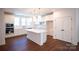 Modern kitchen with white cabinetry, stainless steel appliances, and a large island with overhead lighting at 8010 Elevate Ct, Charlotte, NC 28205