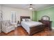 Comfortable bedroom featuring a wood-framed bed, an upholstered chair, and hardwood floors at 820 N Main St, Salisbury, NC 28144