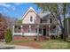 Charming pink two-story home with a welcoming front porch and well-manicured lawn at 820 N Main St, Salisbury, NC 28144