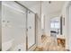 Bathroom featuring a glass-enclosed shower with white tile, wood flooring, and access to the main bedroom at 822 Flatwater Ct, Fort Mill, SC 29708