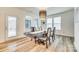 Elegant dining room with modern chandelier, windows for natural light, and wood floors at 822 Flatwater Ct, Fort Mill, SC 29708