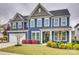 Stunning two-story home with a blue exterior, manicured lawn and colorful landscaping at 822 Flatwater Ct, Fort Mill, SC 29708