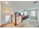 Spacious loft featuring neutral walls, plush carpeting, and an eye-catching chandelier above the staircase at 822 Flatwater Ct, Fort Mill, SC 29708