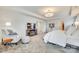 This main bedroom features neutral carpeting, a tray ceiling, and a seating area adjacent to the bedroom at 822 Flatwater Ct, Fort Mill, SC 29708