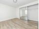 Bright bedroom features a mirrored closet, modern flooring, and ample natural light from the window and door at 8432 Strider Dr, Charlotte, NC 28212