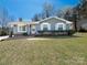 Charming single-story home with a well-maintained lawn, blue siding, and traditional architectural details at 8432 Strider Dr, Charlotte, NC 28212