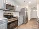 Well-equipped kitchen with stainless steel appliances, light blue cabinets, and marble backsplash at 8432 Strider Dr, Charlotte, NC 28212