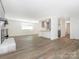 An open floor plan with hardwood floors connecting the living room, dining area, and kitchen at 8432 Strider Dr, Charlotte, NC 28212